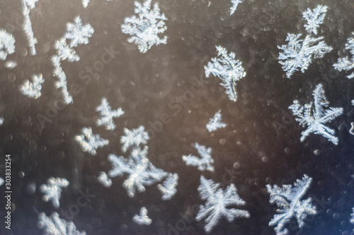 Winter patterns on the window, frozen water, snowflakes, macro photo. photo