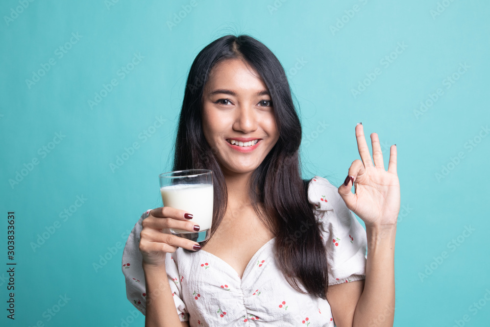 Healthy Asian woman drinking a glass of milk show OK sign. Healthy Asian woman drinking a glass of milk show OK sign.