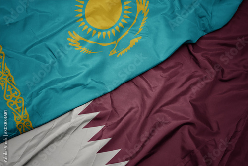waving colorful flag of qatar and national flag of kazakhstan.