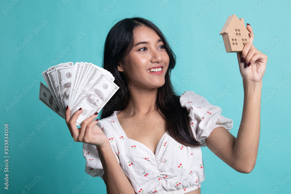 Φωτογραφία Happy young asian woman with house model and bunch of money banknotes