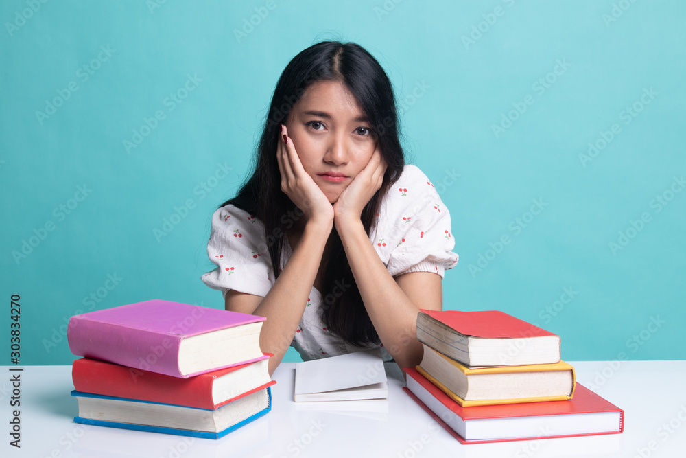 Young Asian woman read a book with books on table. Young Asian woman read a book with books on table.