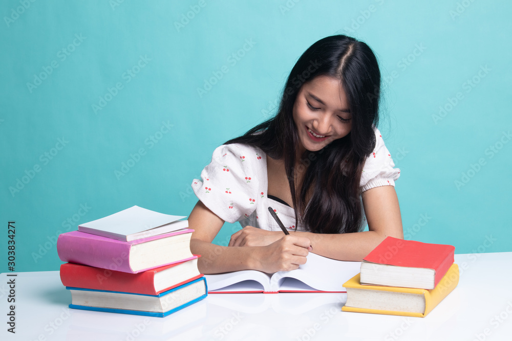 Young Asian woman read a book with books on table. Young Asian woman read a book with books on table.