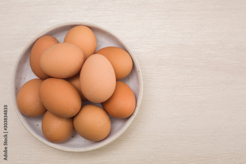Fresh eggs on a bowl rustic background, wood spoon, weighing apparatus.The top view. View from above. Fresh eggs on a bowl rustic background, wood spoon, weighing apparatus.The top view. View from above.