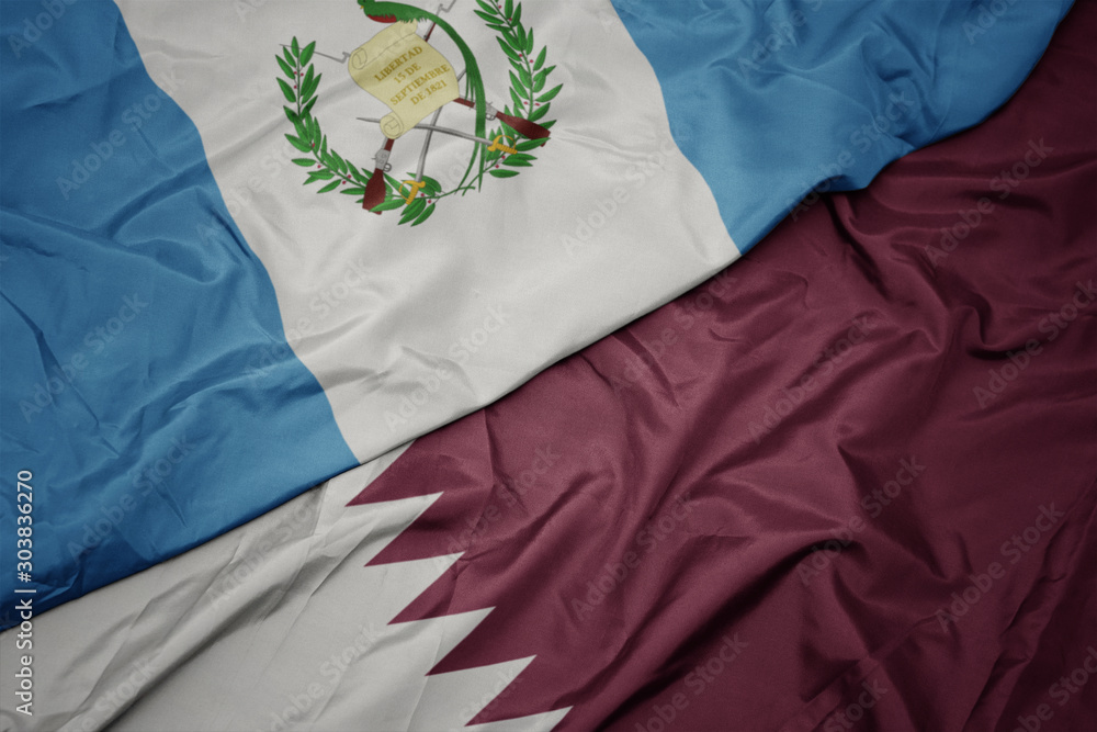 waving colorful flag of qatar and national flag of guatemala.