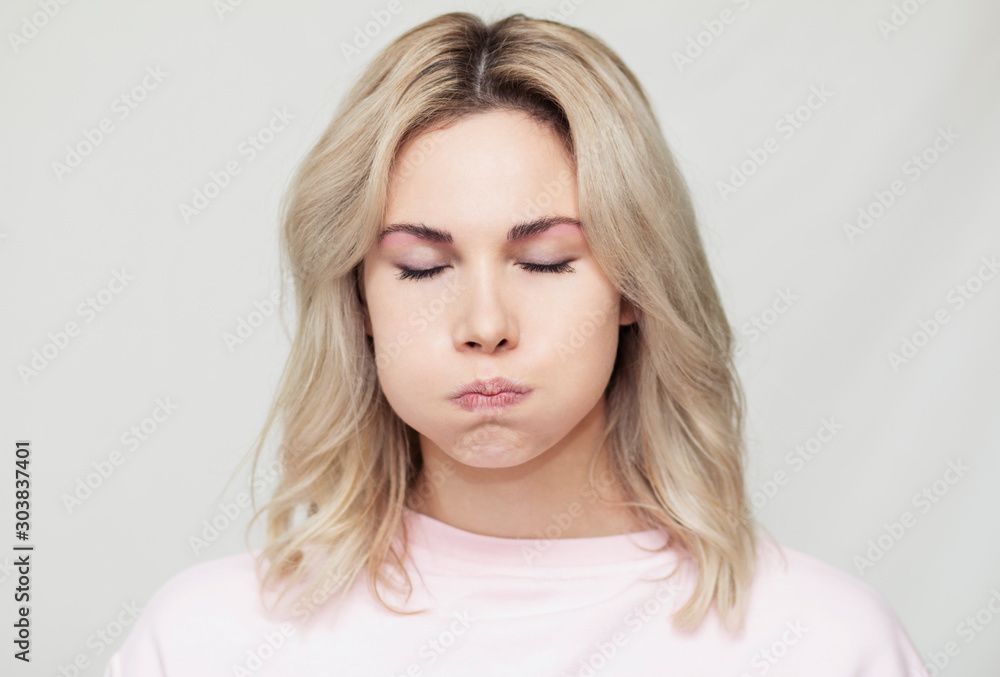 funny beautiful blonde girl grimaces at the camera, she playfully behaves, pink background funny beautiful blonde girl grimaces at the camera, she playfully behaves, pink background