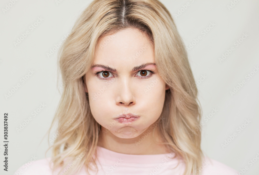 funny beautiful blonde girl grimaces at the camera, she playfully behaves, pink background funny beautiful blonde girl grimaces at the camera, she playfully behaves, pink background