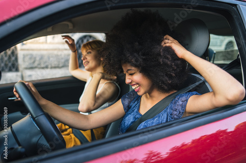 Two young women friends driving in the city - Millennials use the car to get around photo
