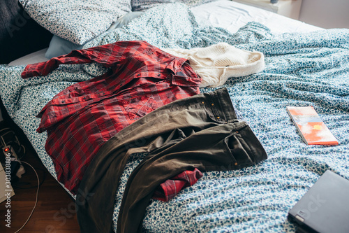 Room with messy clothes scatter on the bed photo