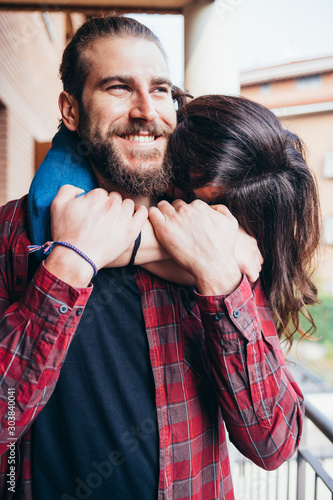 Young beautiful happy couple at home hugging photo