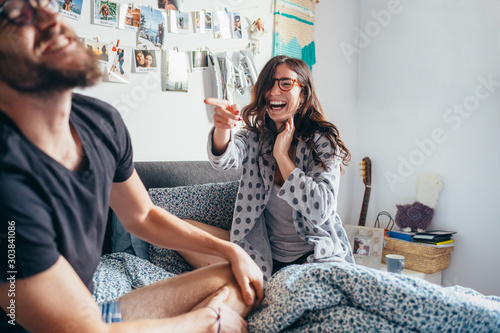 Obraz na płótnie Young happy couple playing laughing on bed indoor home laughing