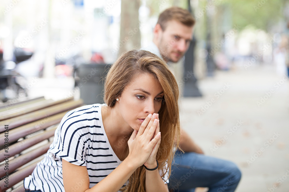 Upset woman and man outdoor on street having relationship problems Upset woman and man outdoor on street having relationship problems