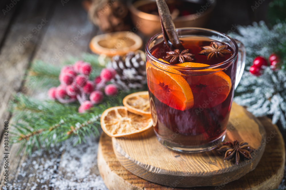 Christmas mulled red wine with spices and fruits on a wooden rustic table. Traditional hot drink at Christmas time Christmas mulled red wine with spices and fruits on a wooden rustic table. Traditional hot drink at Christmas time