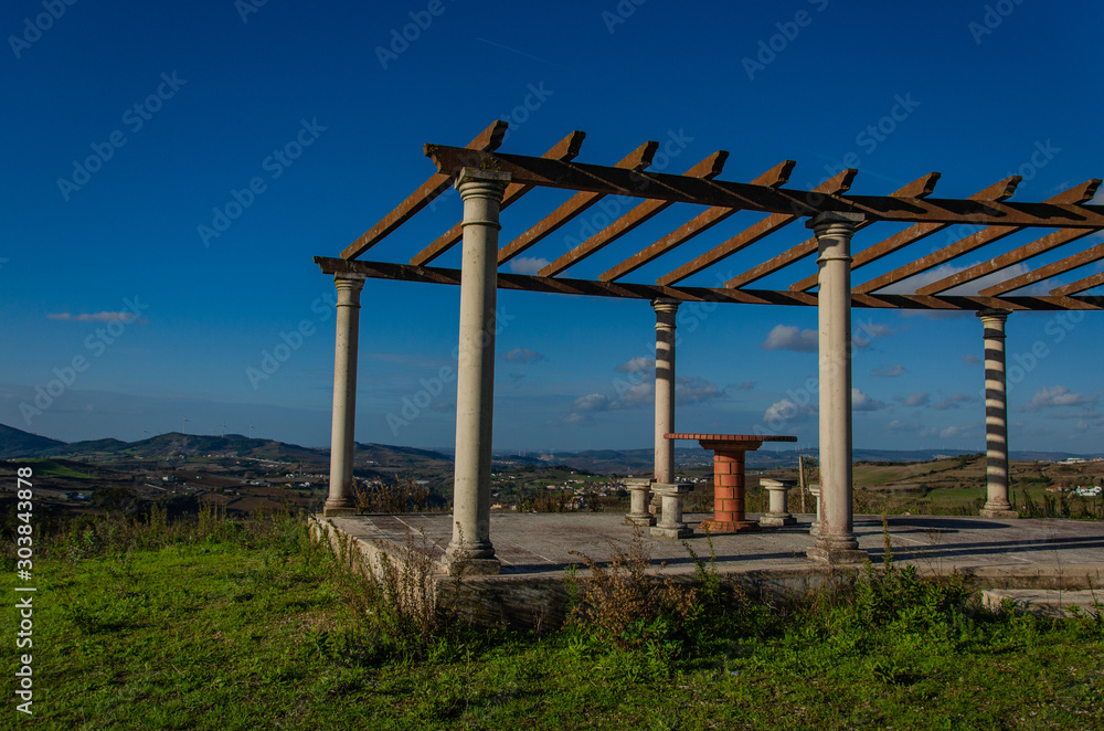 A place to relax on a hill overlooking the houses below. Table and chairs made of stone, roof, gazebo. Portugal A place to relax on a hill overlooking the houses below. Table and chairs made of stone, roof, gazebo. Portugal