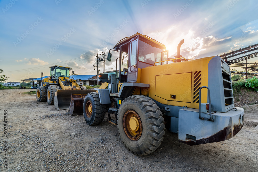 Obraz premium Big excavator on new construction site in the background the blue sky and sun