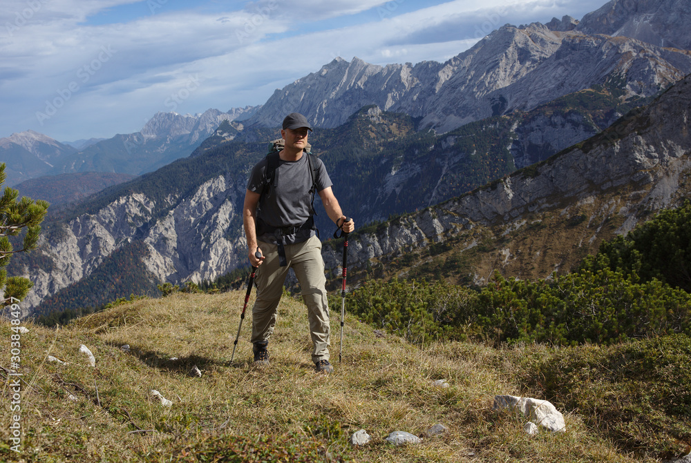 NB__9828 Hiker with backpack and walking sticks on mountain path NB__9828 Hiker with backpack and walking sticks on mountain path