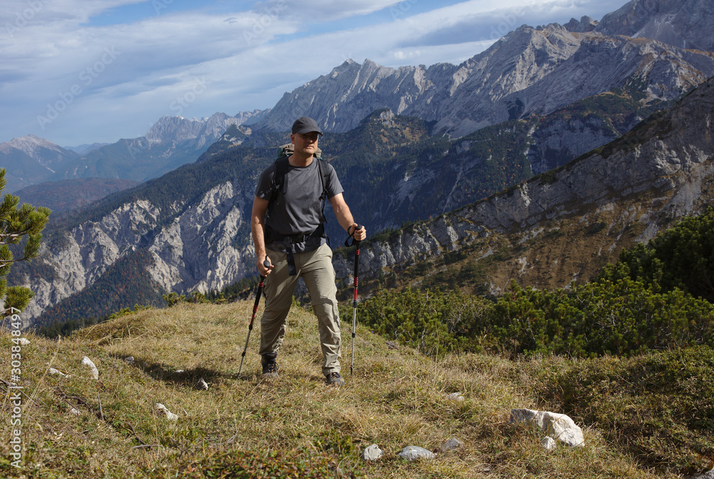 NB__9828 Hiker with backpack and walking sticks on mountain path