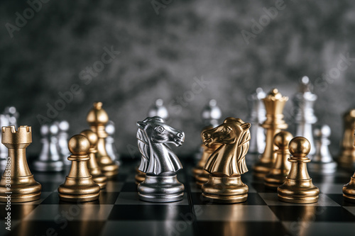 Gold and Silver Chess on chess board game for business metaphor leadership concept
