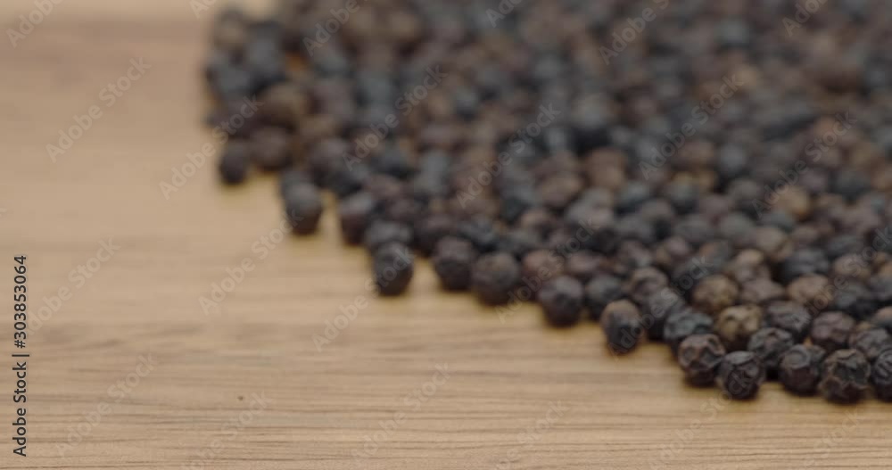 Truck shot of pile black peppers spread on chopper board Truck shot of pile black peppers spread on chopper board