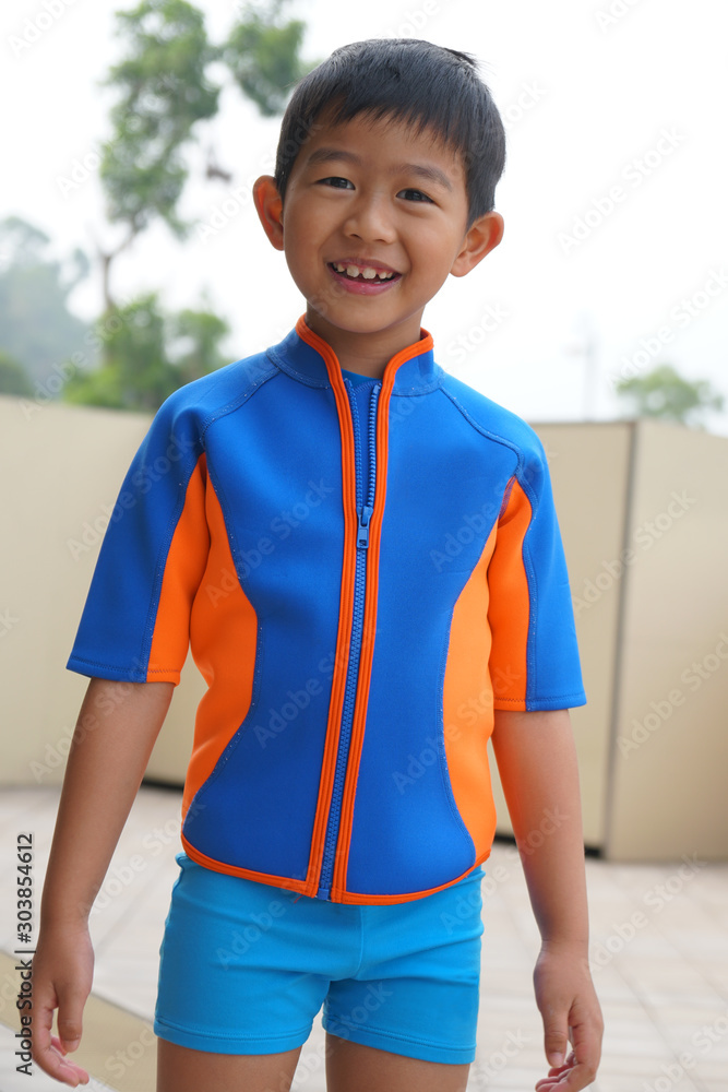 The lovely smiling Asian boy in the wet swimming suit Stock Foto Adobe Stock