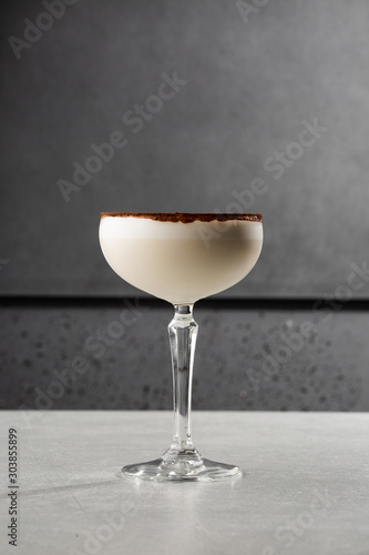 Glasses of Irish cream liqueur with anise, cocoa and ice on gray background. Selective focus. Overhead view, copy space. Advertising for cafe. Bar menu. Vertical photo.