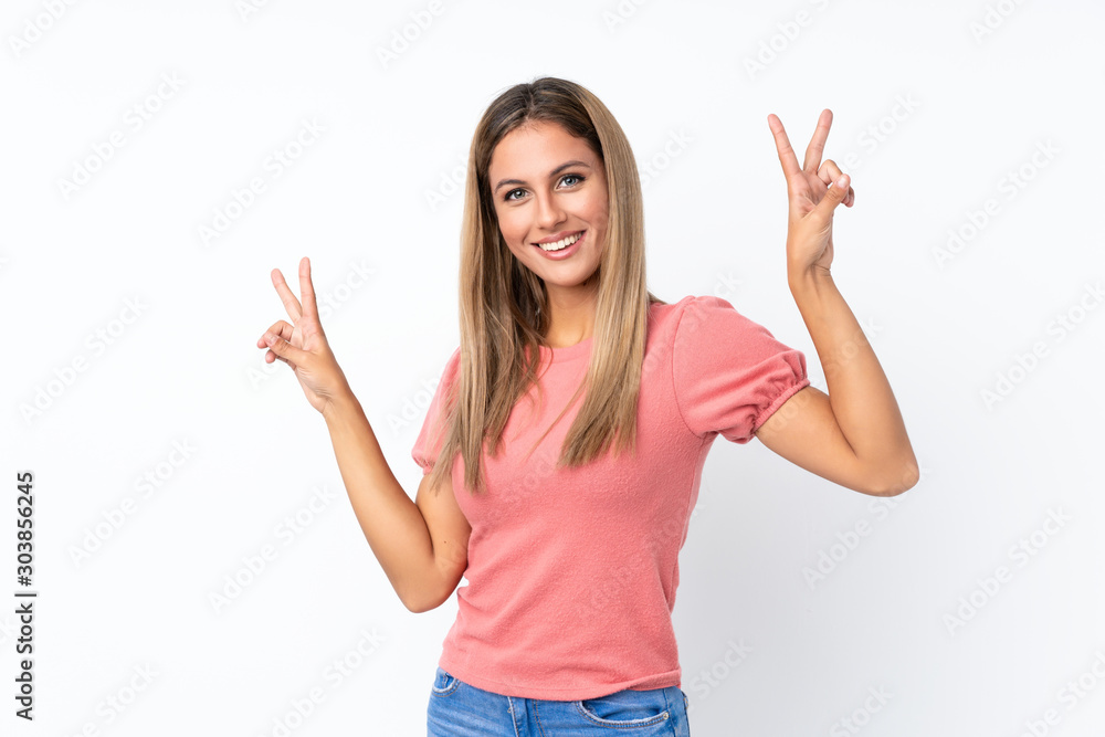 Young blonde woman over isolated white background showing victory sign with both hands Young blonde woman over isolated white background showing victory sign with both hands