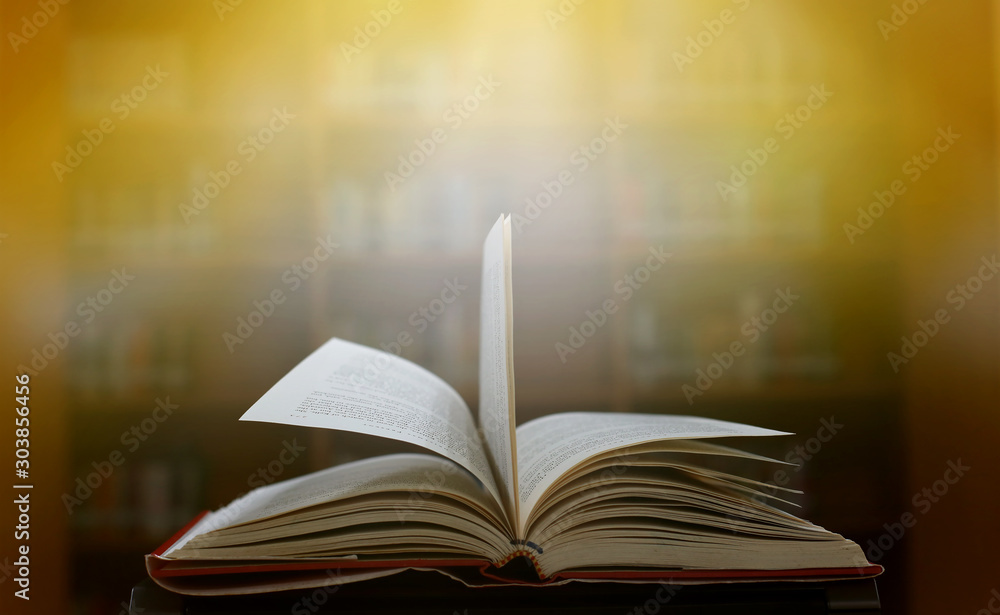 Obraz premium Stack of books in the library and blur bookshelf background