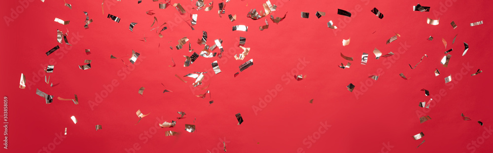 panoramic shot of christmas golden confetti isolated on red - obrazy, fototapety, plakaty 
