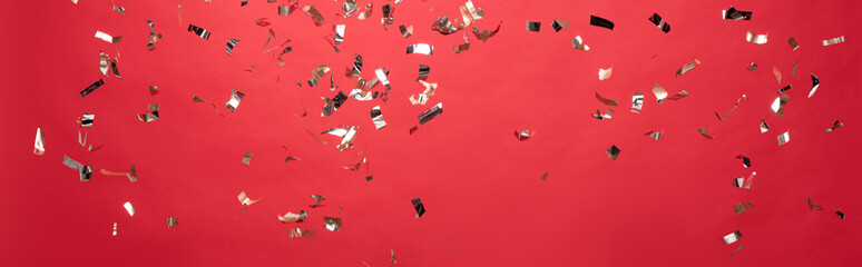 panoramic shot of christmas golden confetti isolated on red