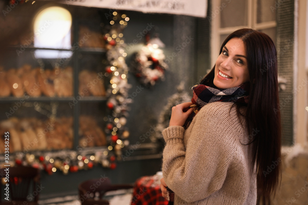 Beautiful woman in decorated cafe, space for text. Christmas celebration Beautiful woman in decorated cafe, space for text. Christmas celebration