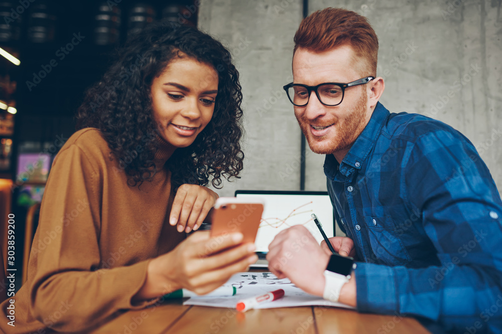 Φωτογραφία Skilled male and female millennial colleague reading information from cellular w