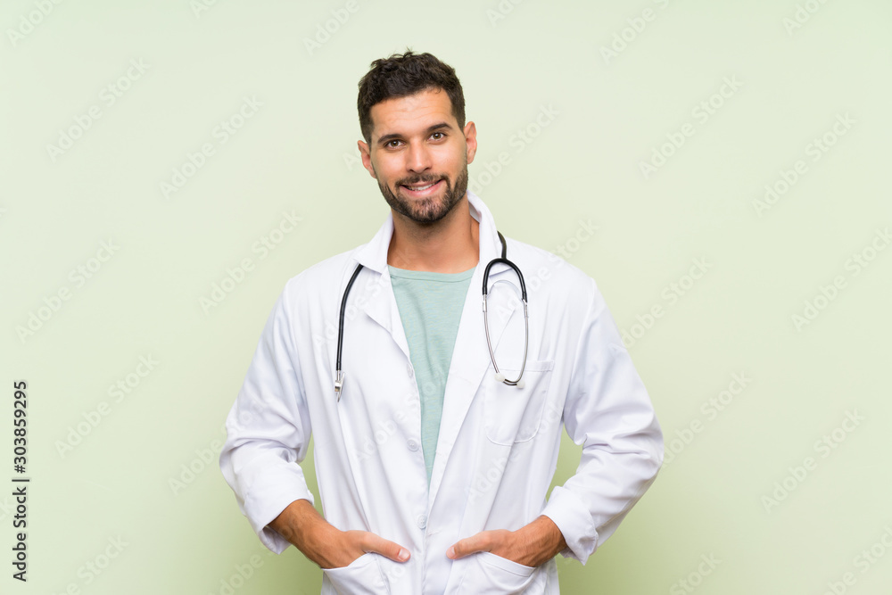 Young doctor man over isolated green wall Young doctor man over isolated green wall
