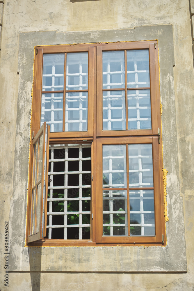 Wooden modern window frames in an old house, open window