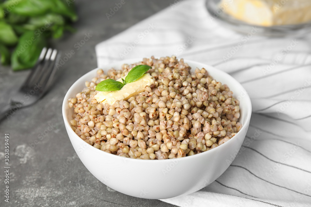 Tasty buckwheat porridge with butter on grey table Tasty buckwheat porridge with butter on grey table
