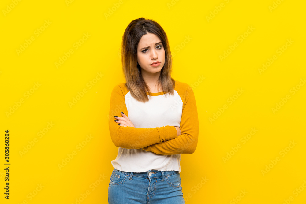 Pretty young woman over isolated yellow wall feeling upset Pretty young woman over isolated yellow wall feeling upset