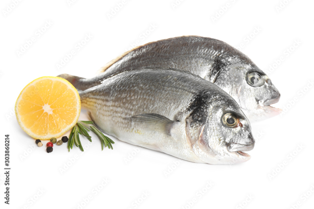 Raw dorada fish with lemon and spices isolated on white Raw dorada fish with lemon and spices isolated on white