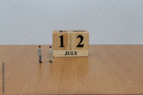 July 12, a calendar photo from the wood The table top consists of a book and pen that is ready to use. White background