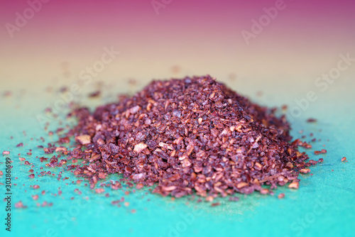 Sumac spice with macro lens photographed against colorful gradient in studio