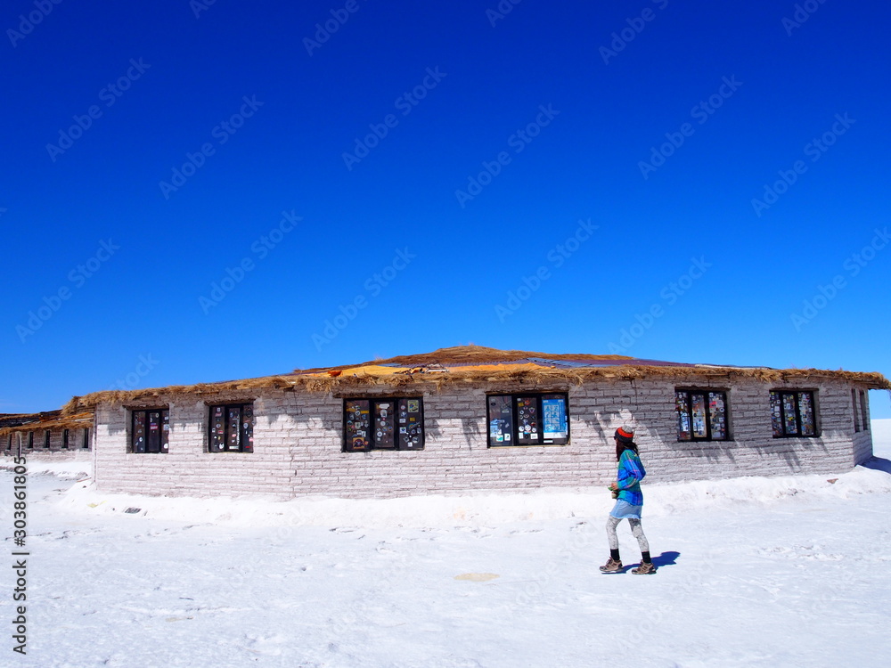 Φωτογραφία A woman tourist walking towards a hotel made of salt, Salar de Uyuni, Salar de U
