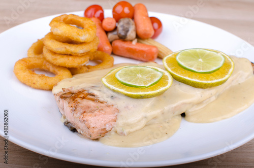 Roasted salmon, served with fried breaded onion rings and vegetables