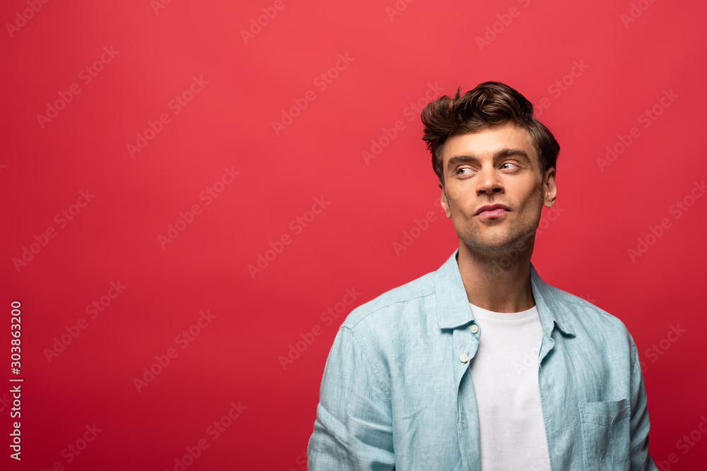portrait of handsome thoughtful man in casual clothes isolated on red portrait of handsome thoughtful man in casual clothes isolated on red