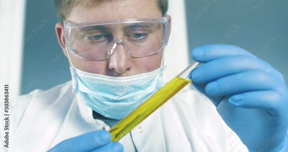 Scientist Analyzes the Fluid in a Test Tube in Laboratory and Working with Toxic Liquids. Close up 4k. Science concept. Scientist Analyzes the Fluid in a Test Tube in Laboratory and Working with Toxic Liquids. Close up 4k. Science concept.