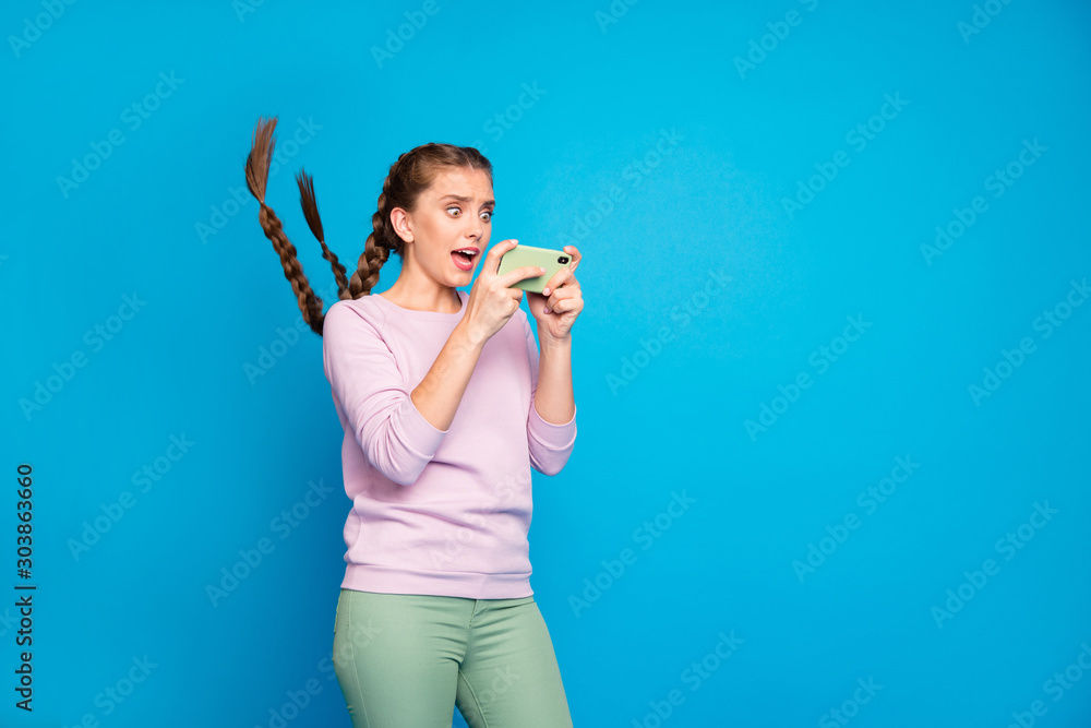 Its me. Unbelievable. Portrait of astonished blogger youth girl look cell phone after making selfie scream omg have her hairdo fly by wind blowing wear modern clothing isolated blue color background Its me. Unbelievable. Portrait of astonished blogger youth girl look cell phone after making selfie scream omg have her hairdo fly by wind blowing wear modern clothing isolated blue color background