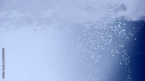 Beady bubbles shot into clear water like an oxygen explosion. Slowmotion 240fps photo