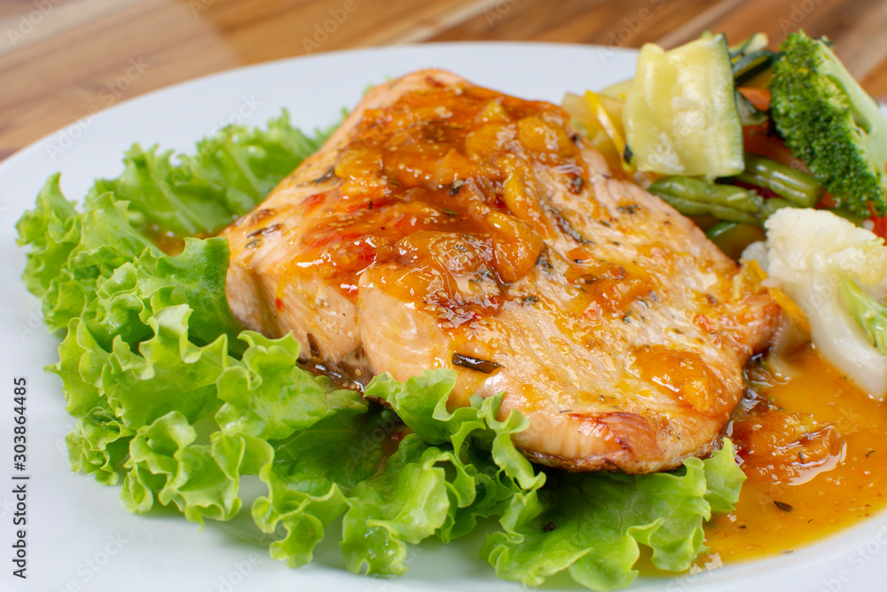 Salmon fillet in citrus sauce, fried plantain and vegetables Salmon fillet in citrus sauce, fried plantain and vegetables