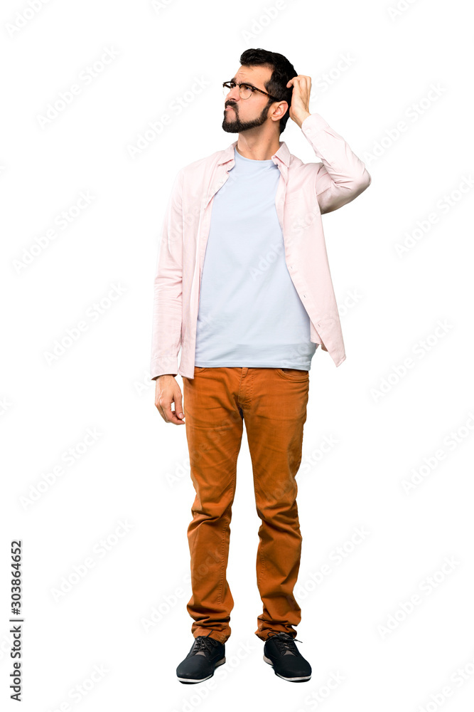 Full-length shot of Handsome man with beard having doubts while scratching head over isolated white background Full-length shot of Handsome man with beard having doubts while scratching head over isolated white background