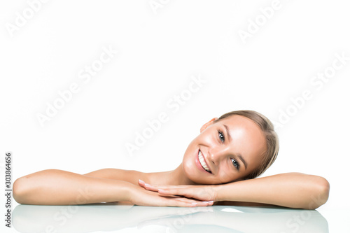 Beautiful woman applying cosmetic cream treatment on her face on white background