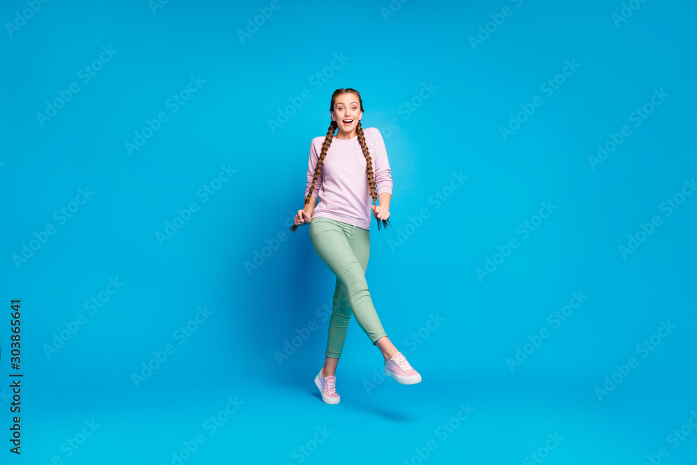 Full length photo of content funny millennial girl holding her tails making step want hurry to her friend she wait on holidays wear good looking outfit isolated over blue color background