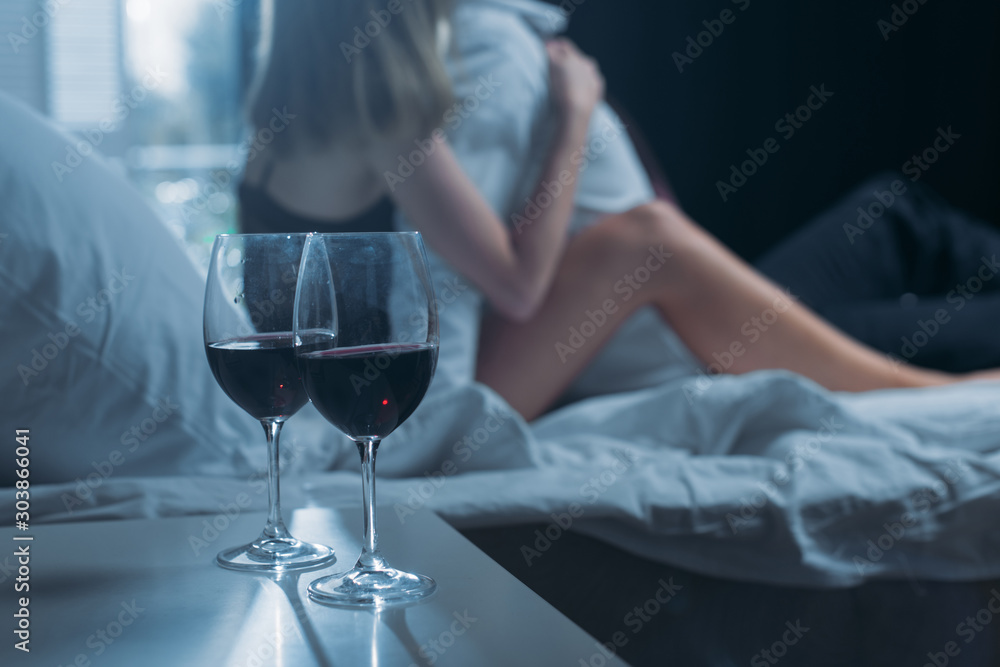 selective focus of wine glasses on wooden table in apartment