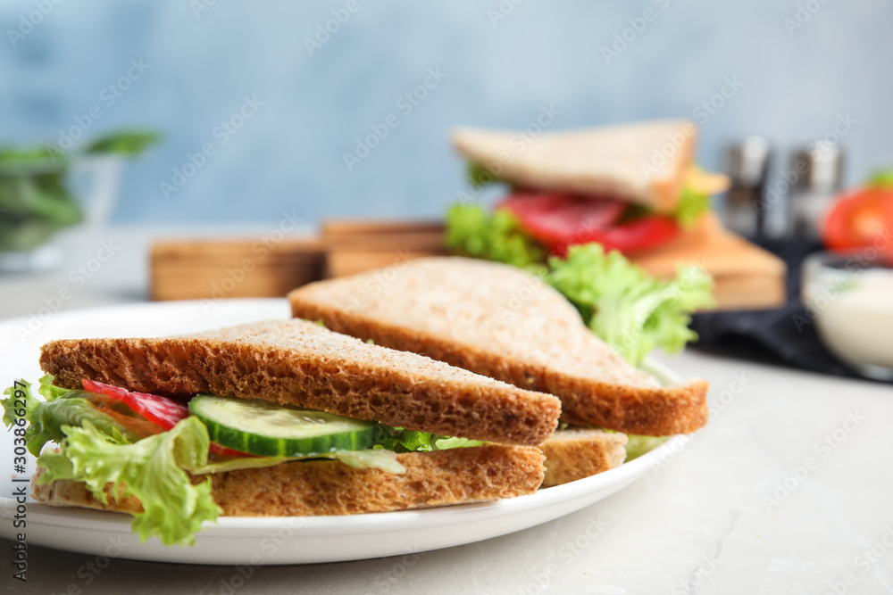 Tasty fresh sandwiches with cucumbers and sausage on light grey table, closeup Tasty fresh sandwiches with cucumbers and sausage on light grey table, closeup