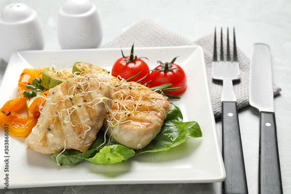 Tasty grilled fish served on light grey table